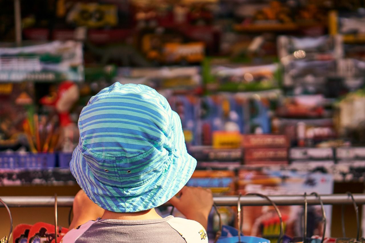 Uma pequena criança observando uma vitrine de uma loja de brinquedo.
