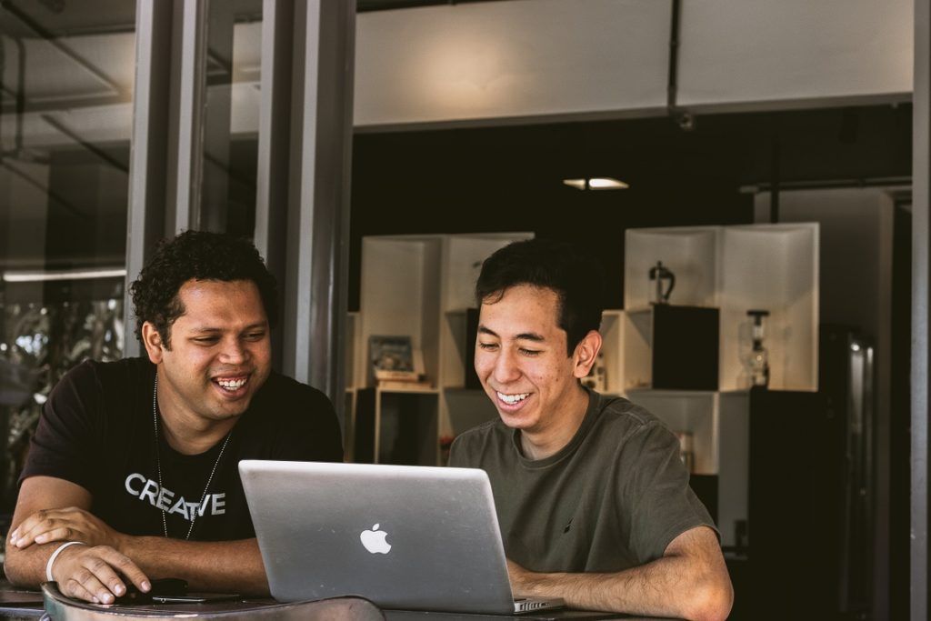 Dois rapazes trabalhando em um notebook