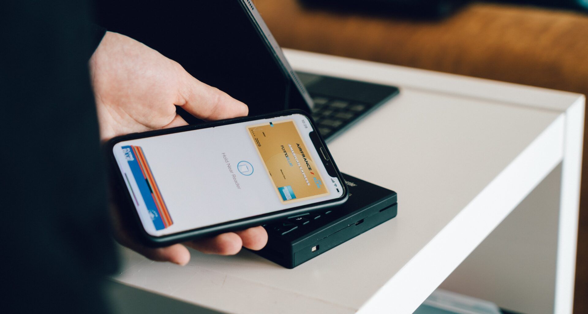 Homem realizando um pagamento por aproximação utilizando seu celular.