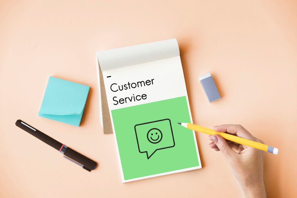 Uma pessoa planejando seu "Customer Service" em um bloco de anotações